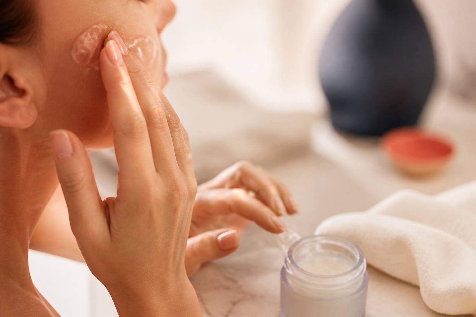 Mains appliquant une fine couche de gelée sur une joue