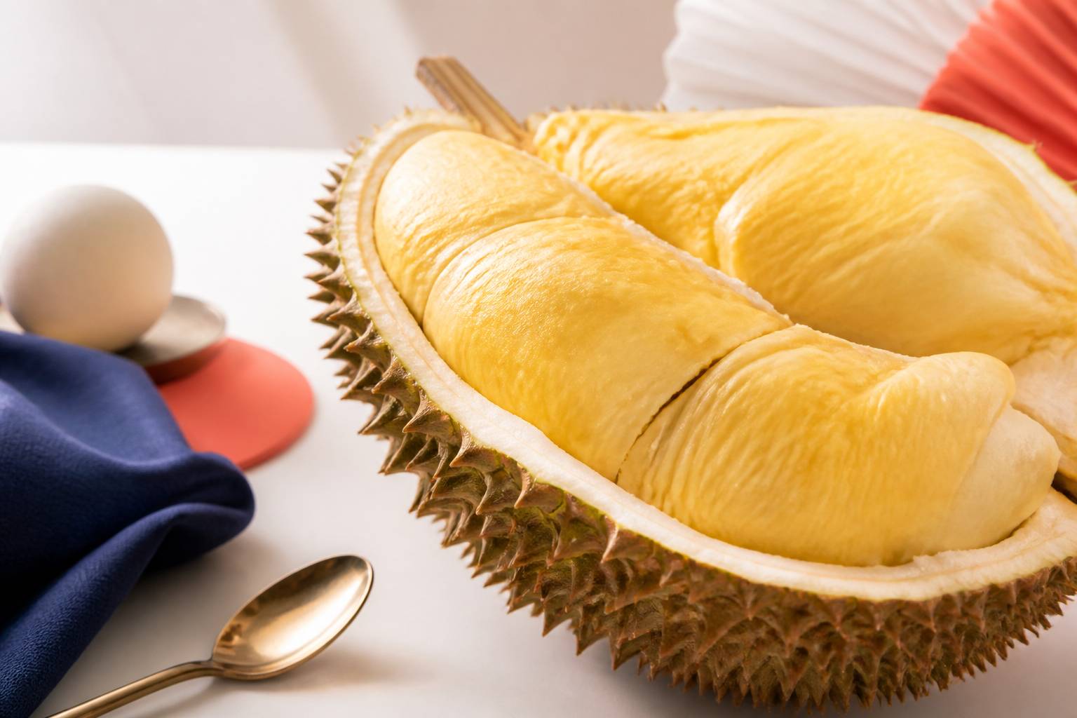 Gros plan de la chair crémeuse d'un durian ouvert avec une cuillère