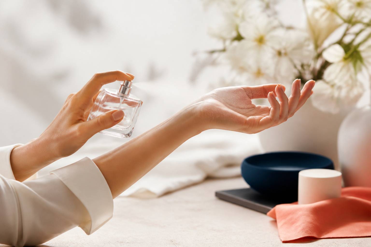 Mains vaporisant un parfum sans marque sur un poignet