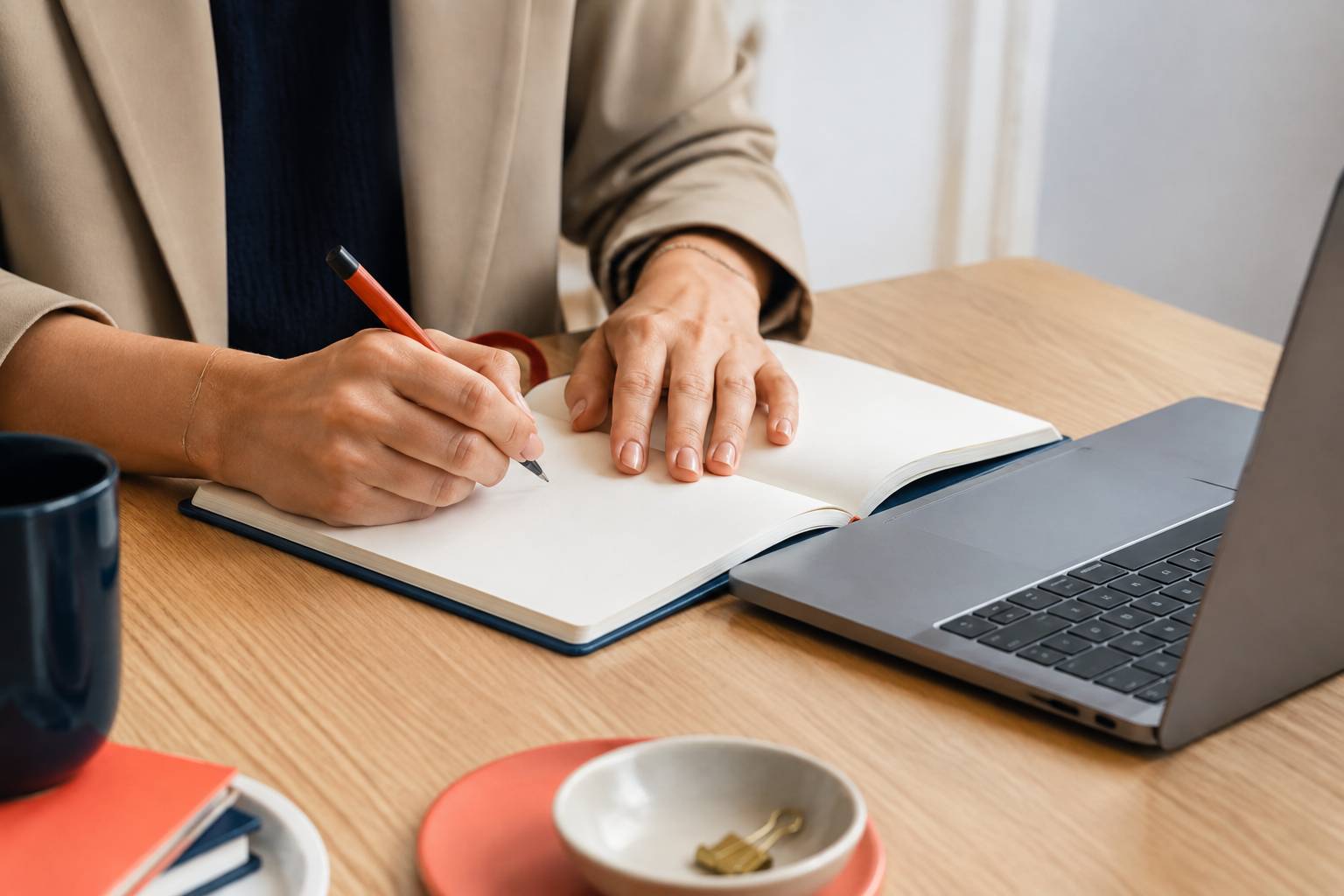 Mains écrivant des notes stratégiques dans un carnet sur un bureau moderne